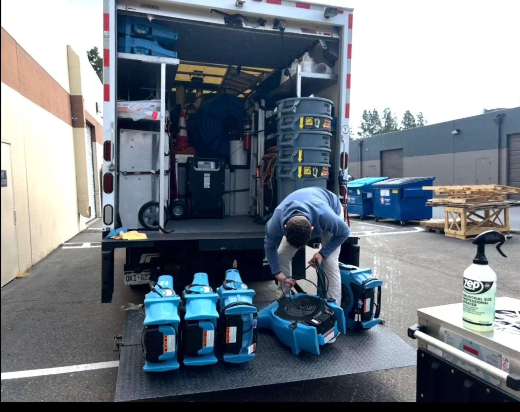 Technician unloading air movers from the back of a box truck