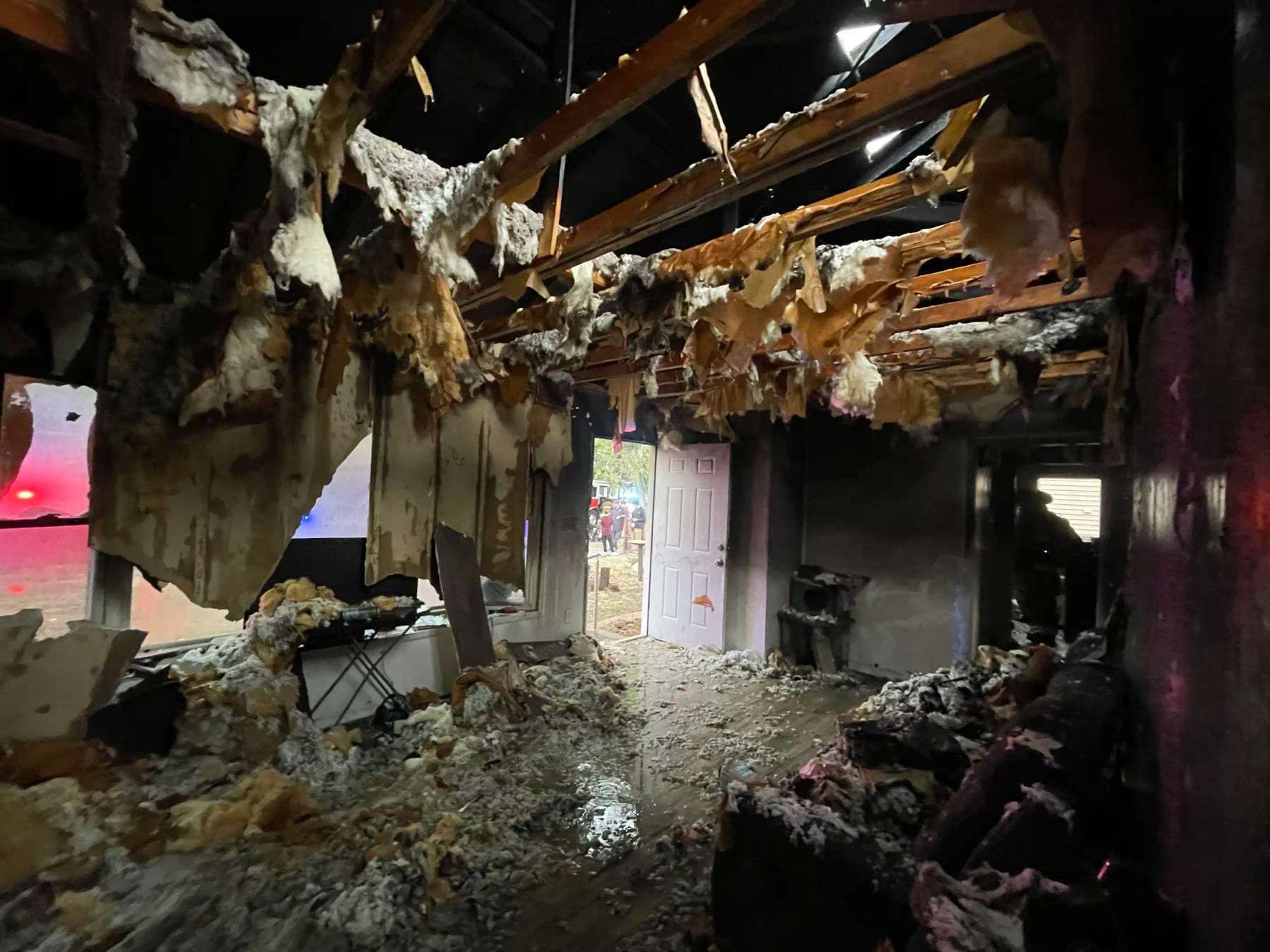 Interior gutted by fire with collapsed ceiling insulation hanging down