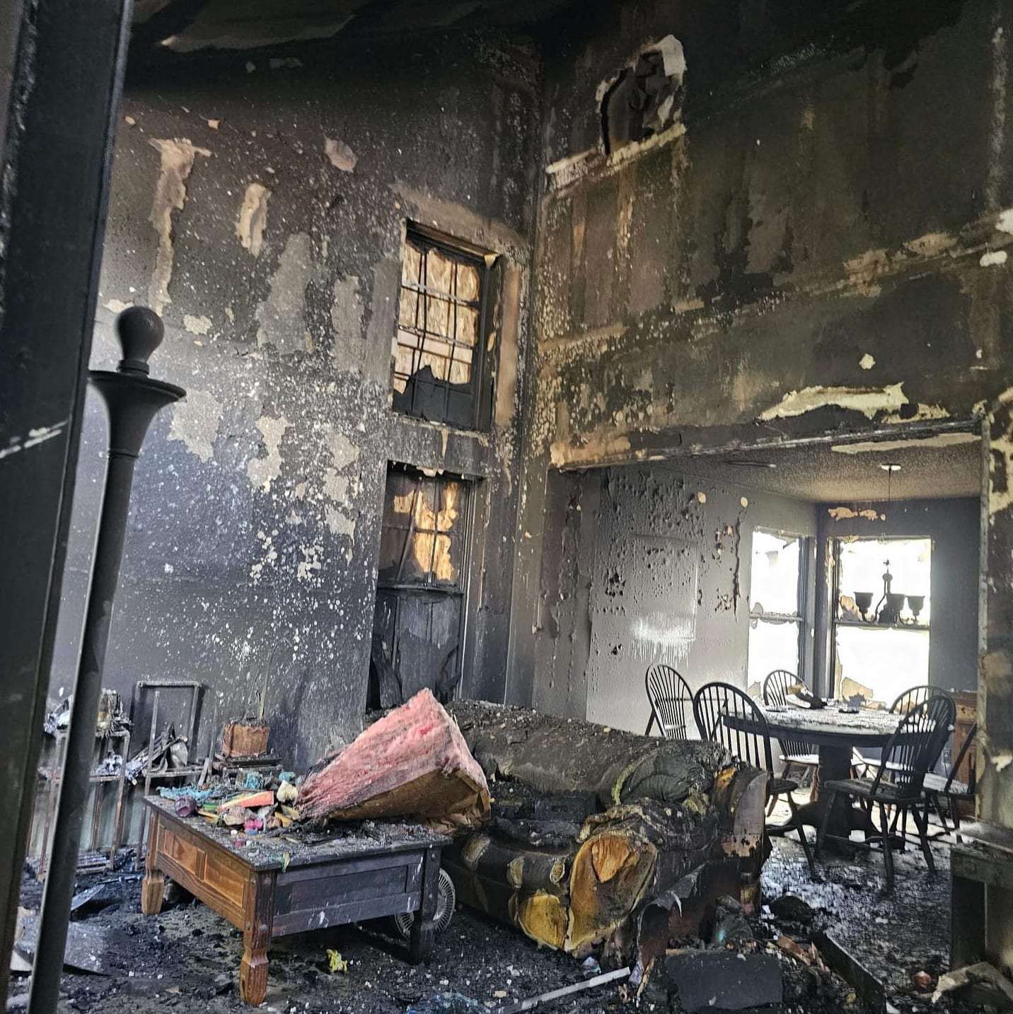 Fire-gutted living room with charred furniture
