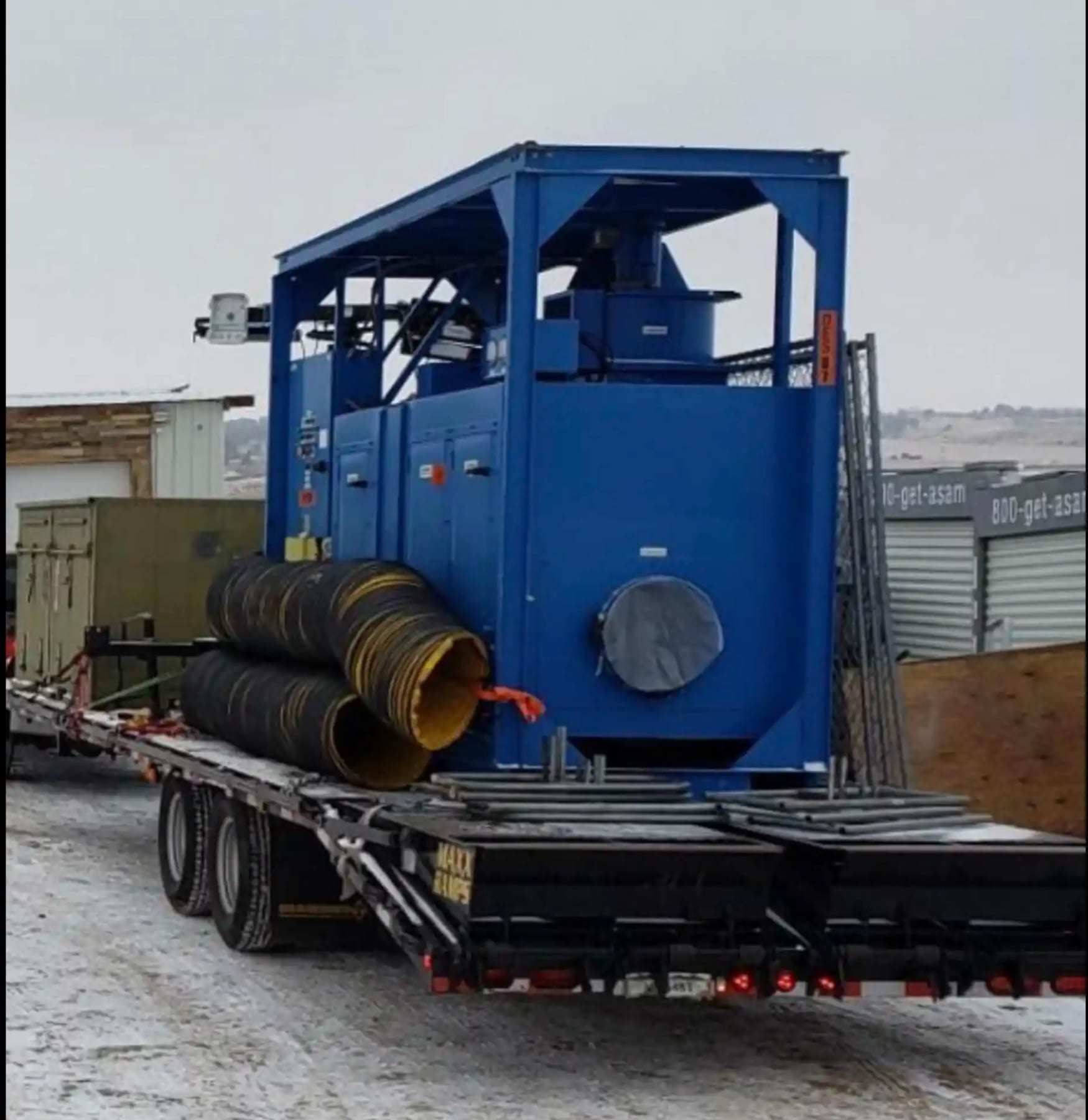 Trailer-mounted industrial desiccant dehumidifier with its ducting coiled on the bed