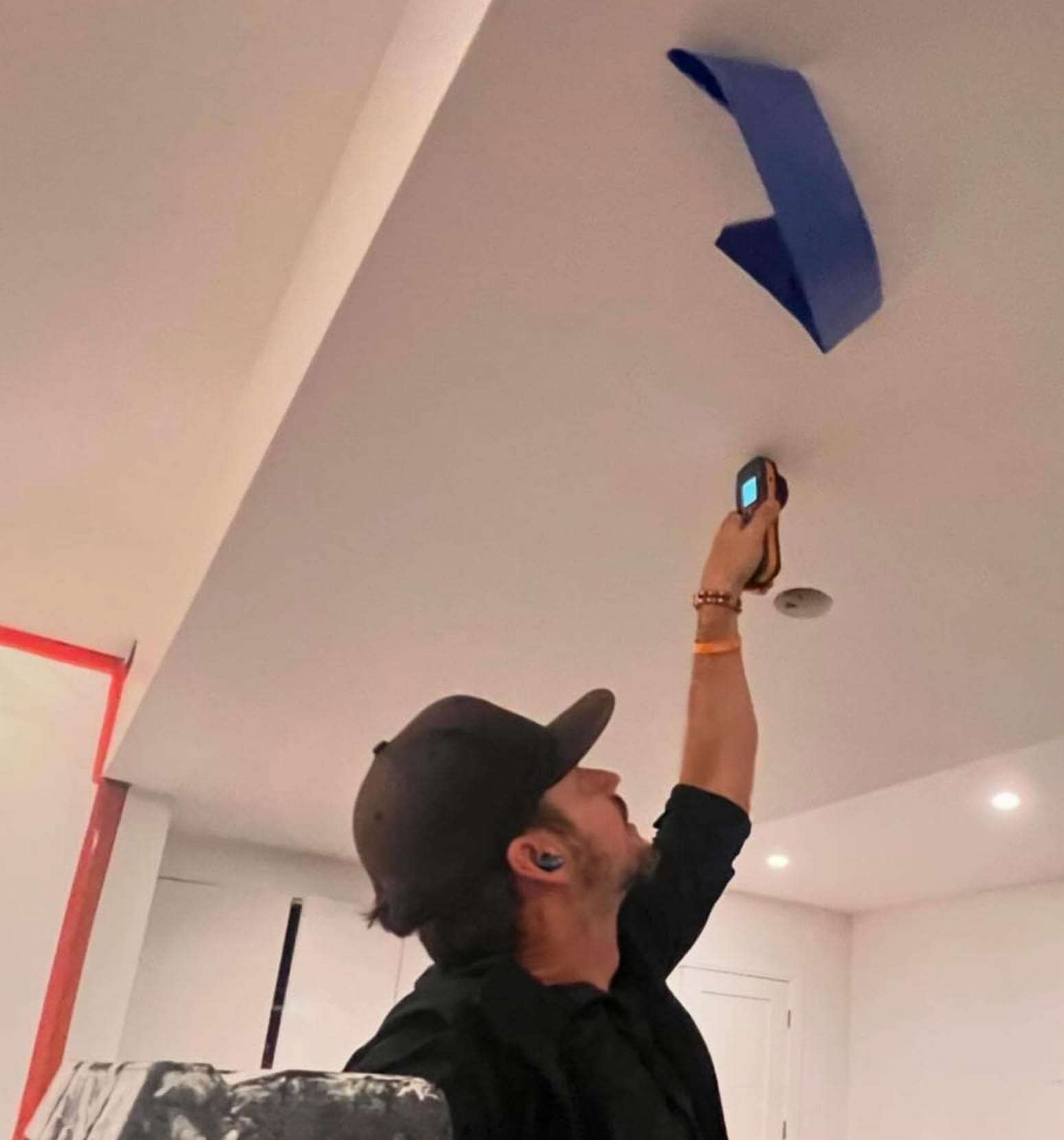 Technician taking a temperature reading at a ceiling