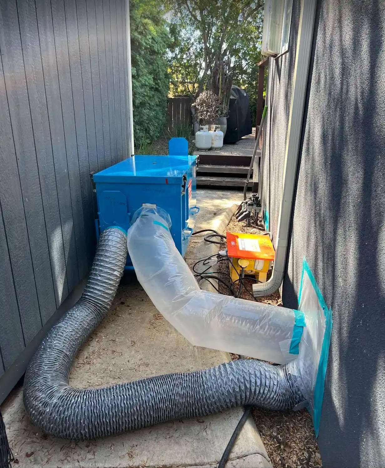 Dehumidifier ducting run through an opening in a home's exterior wall