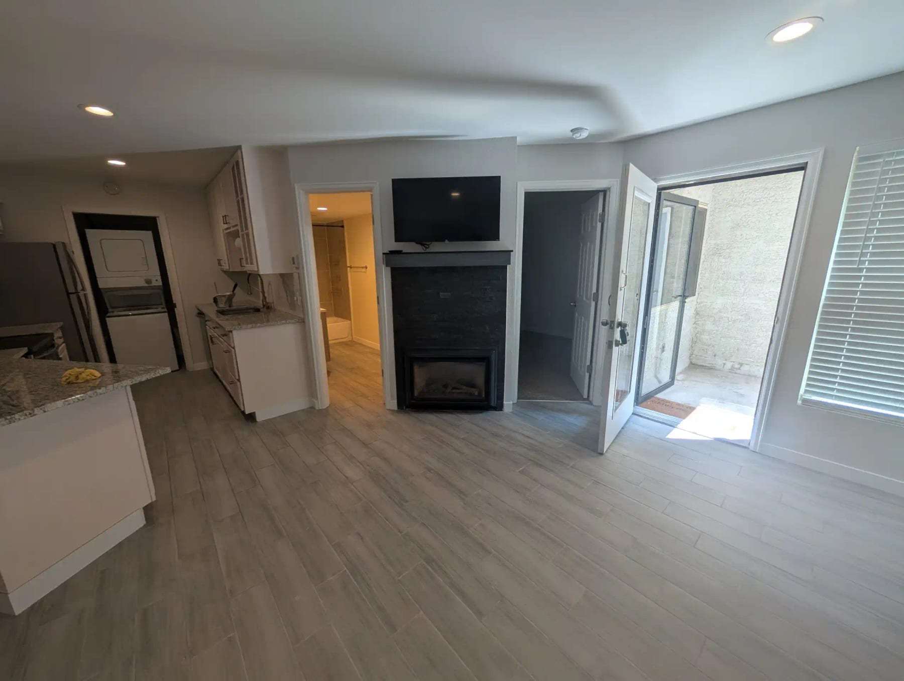 Empty finished living room with a fireplace and plank flooring