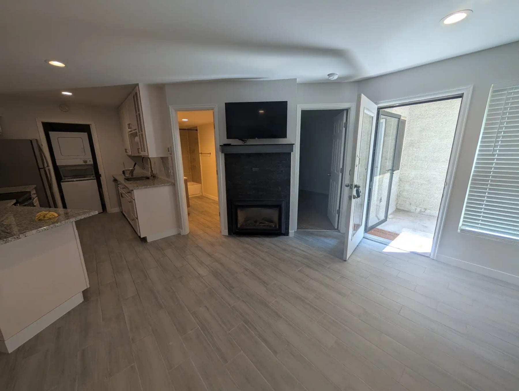 Empty finished living room with a fireplace and plank flooring