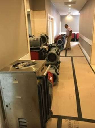 Hotel corridor with dehumidifiers and air movers
