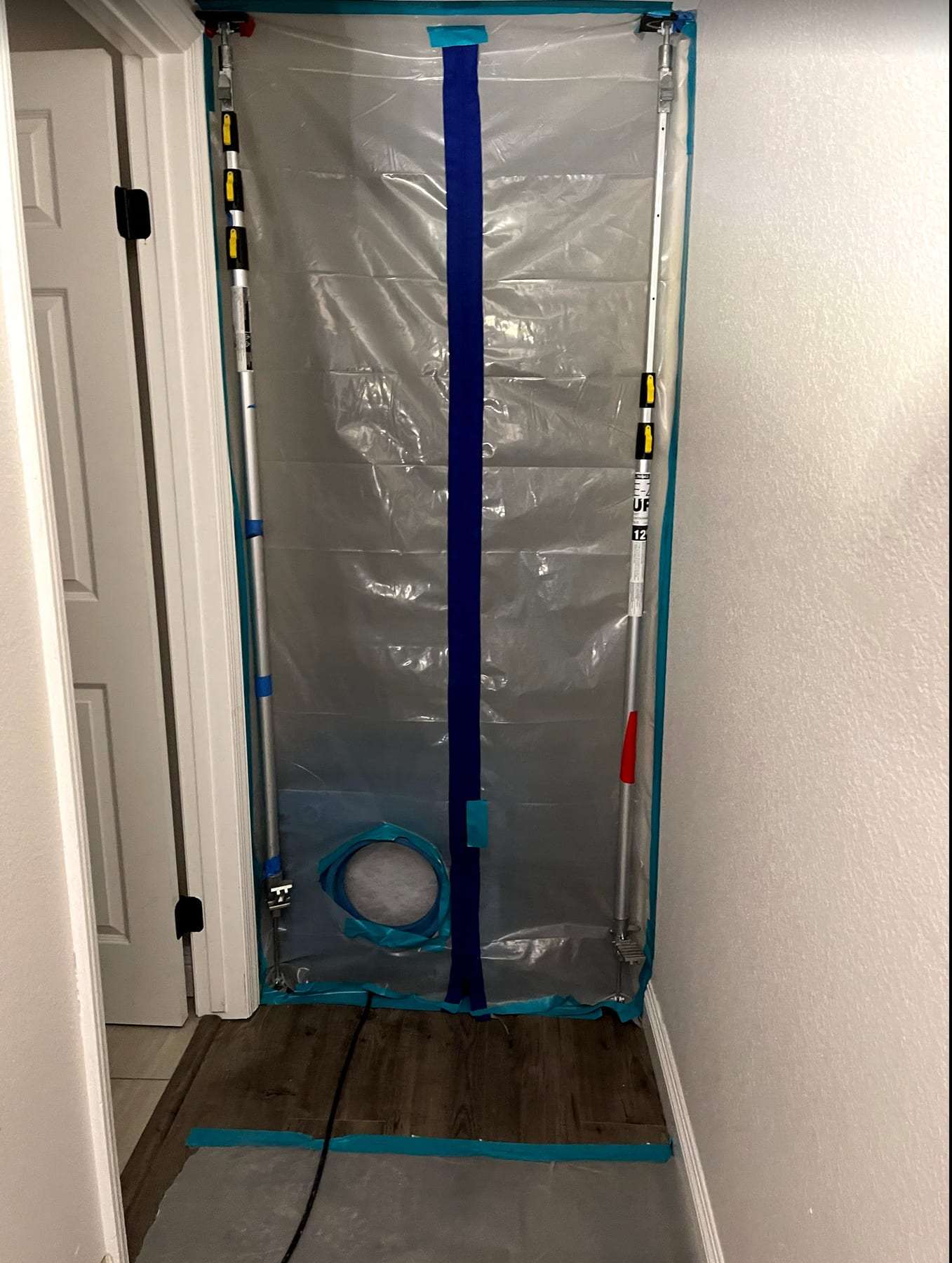 Zipper-door plastic containment sealing off a hallway