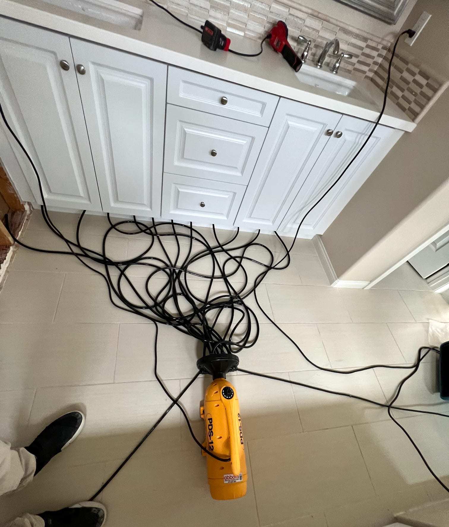 Bathroom vanity with hoses feeding a cabinet drying system