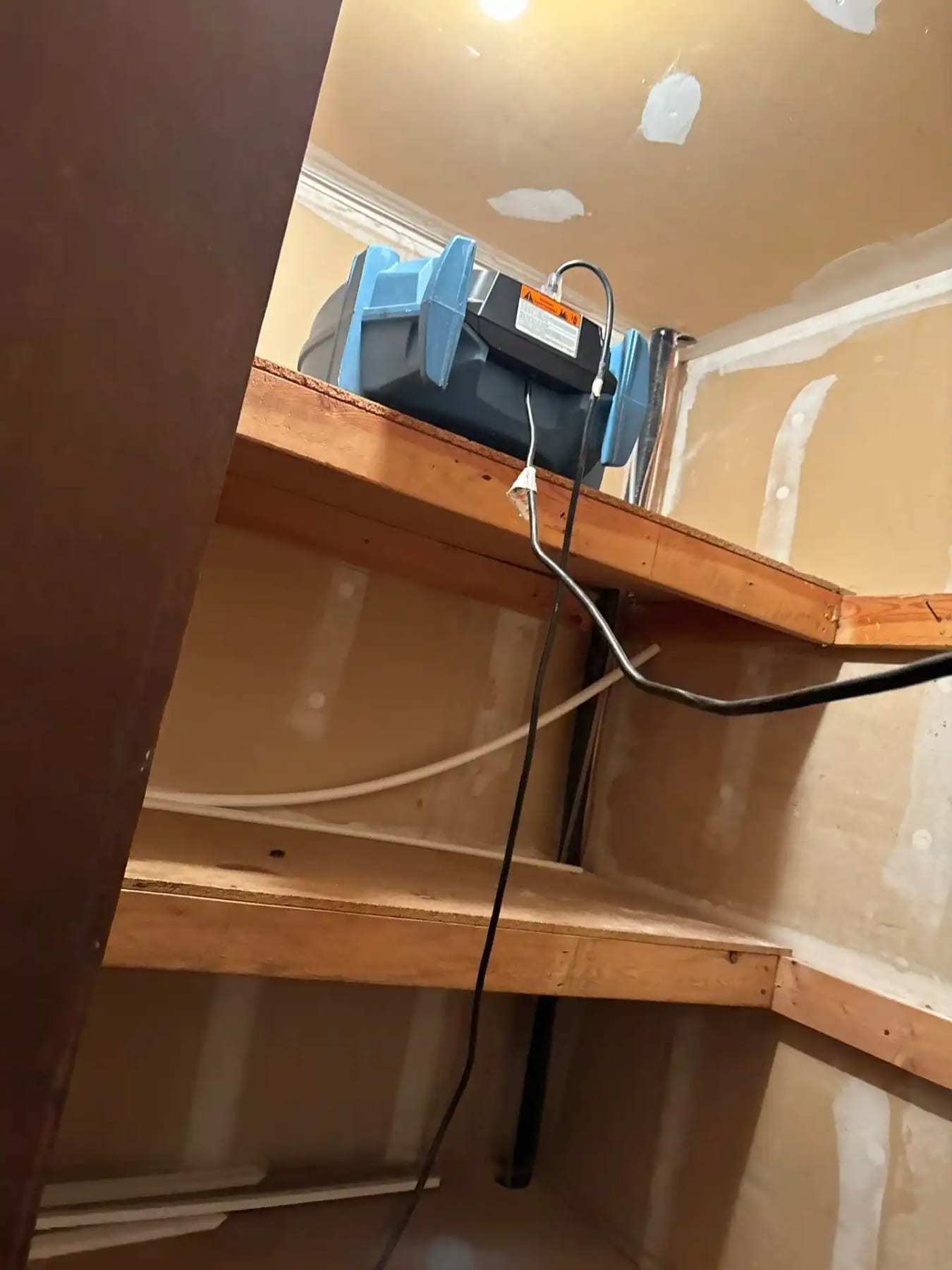 Dehumidifier drying the space under a staircase