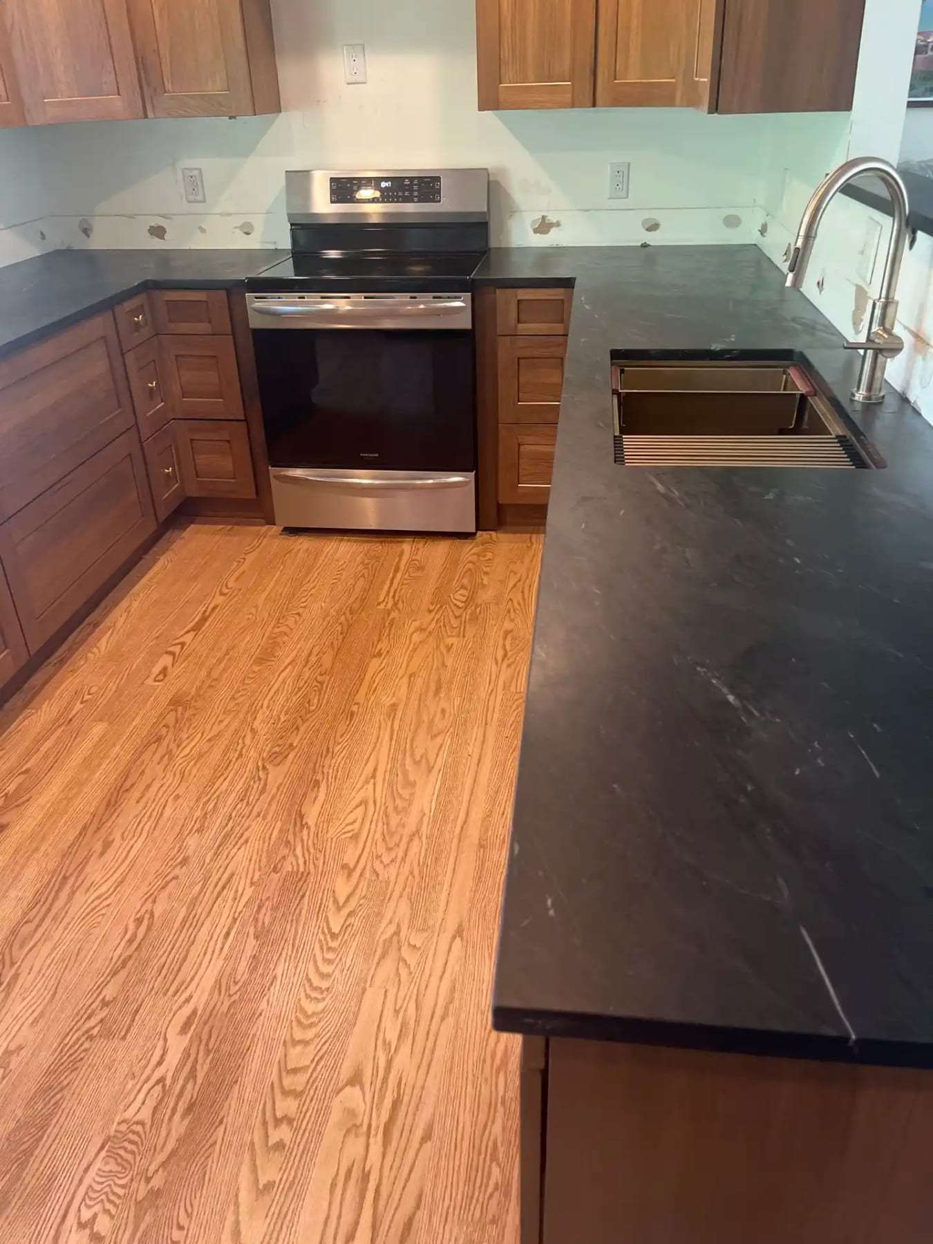 Finished kitchen with new oak flooring and dark countertops