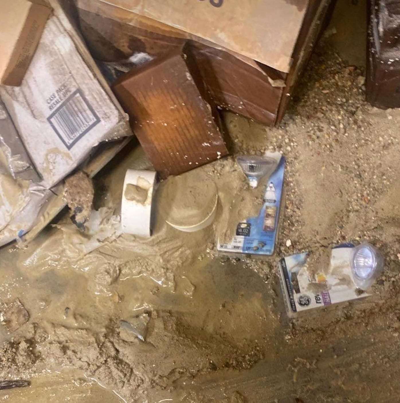 Flood-damaged basement with soaked boxes and debris