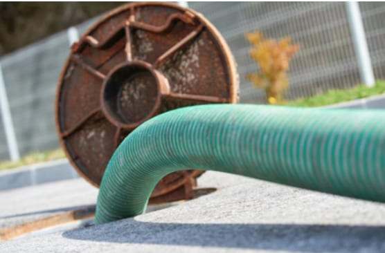 Lay-flat hose running into an open manhole