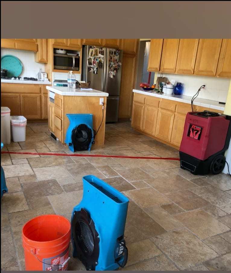 Kitchen water drying setup with air movers and a dehumidifier