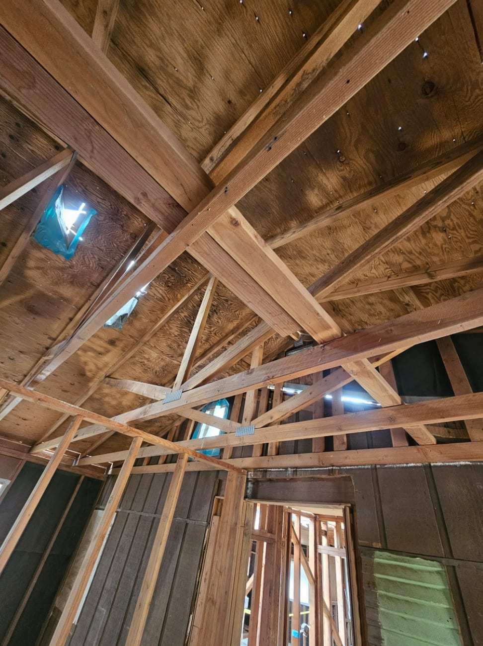 Fire-darkened roof framing seen from below