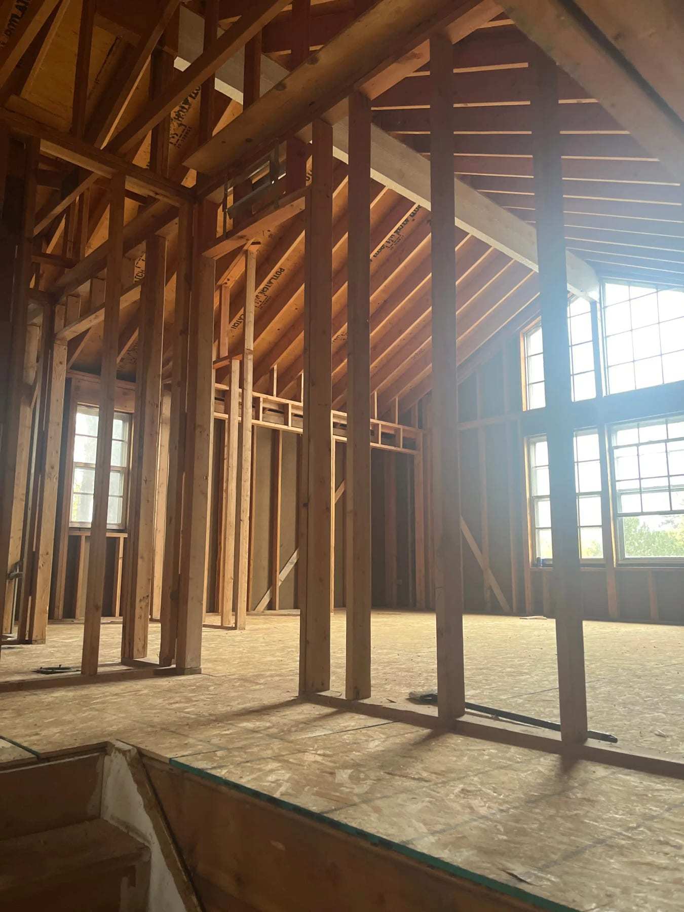 House interior stripped to the framing with sunlight through the windows