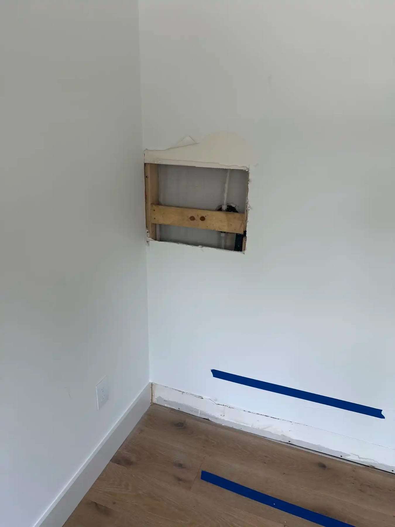 Small inspection opening cut into a wall above the baseboard